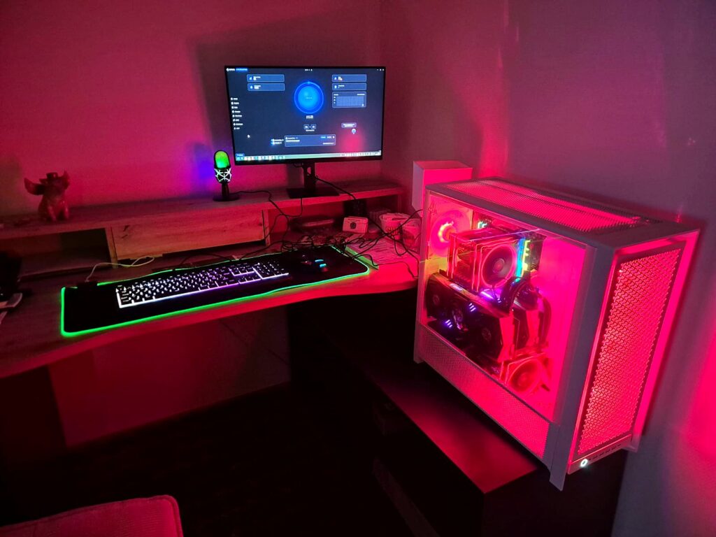 Weisser KI-Server mit rotem Licht neben Monitor und beleuchteter Tastatur im Zimmer